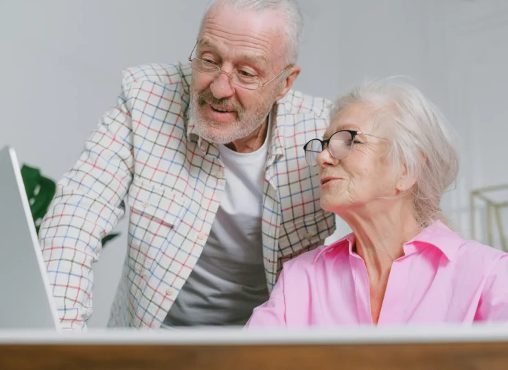 pareja de jubilados mirando una computadora