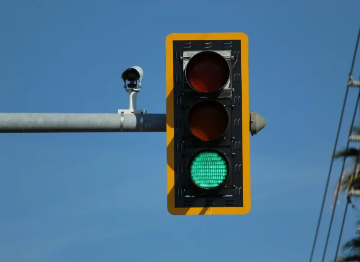 semaforo en verde con una camara de seguridad y transito