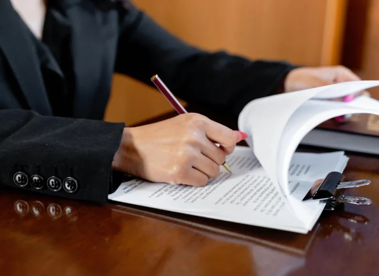 abogada firmando documentos en su escritorio